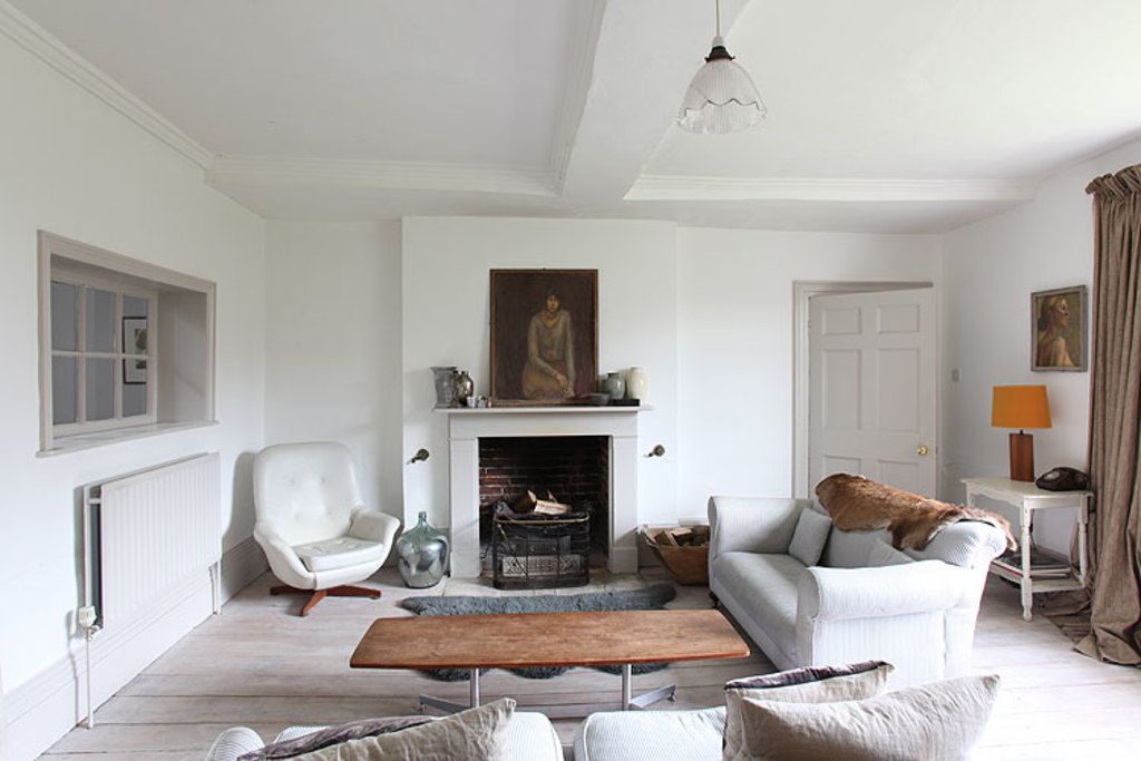 Calm white living room with a fireplace and soft armchairs